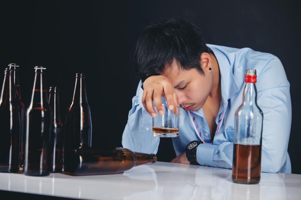 alcoholic-asian-man-drinking-whisky-with-lot-bottles.jpg